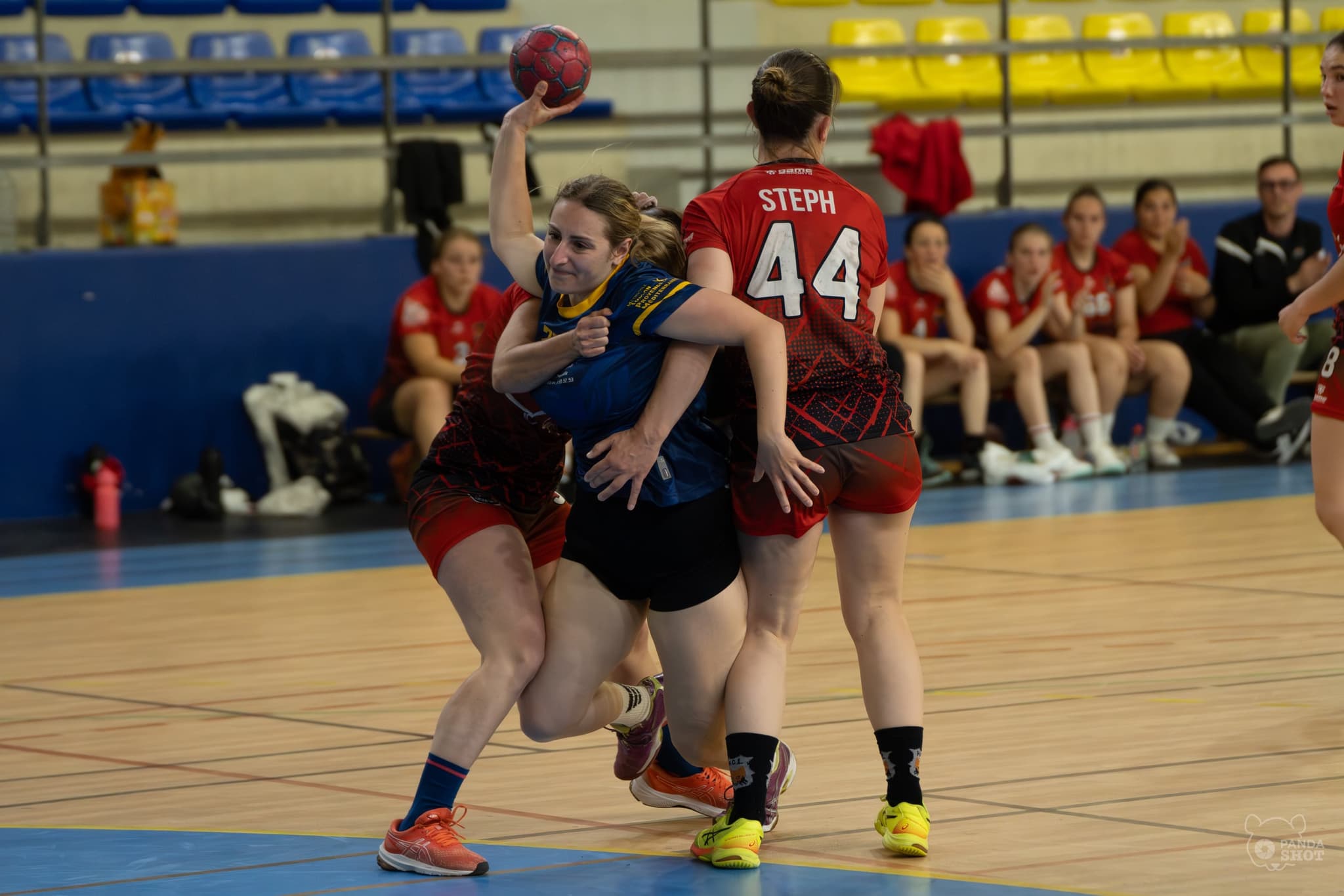 Une handballeuse de Toulon s'extrait de deux défenseuses, ballon levé à bout de bras