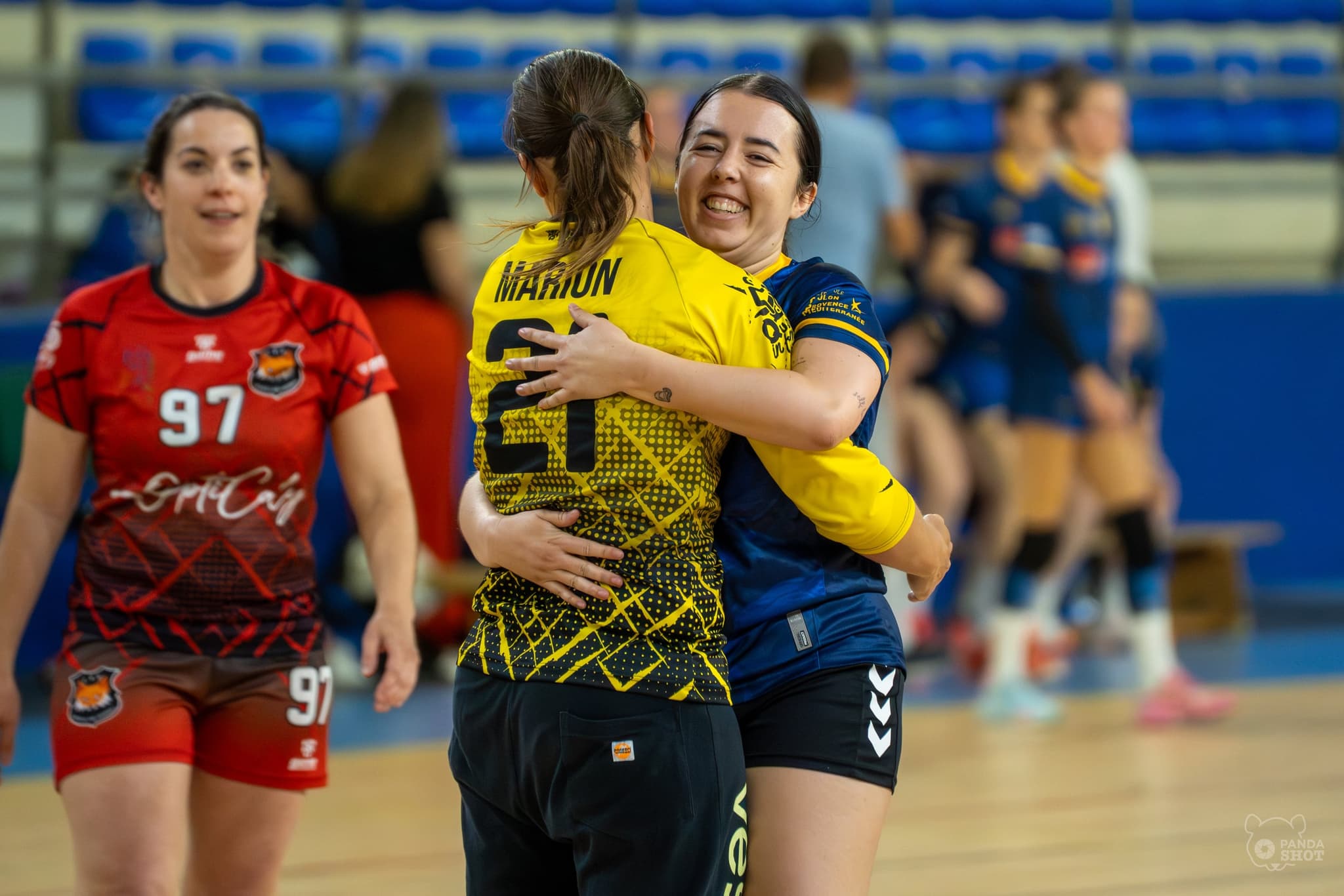 Deux joueuses s'étreignent après la rencontre, maillots adverses mêlés