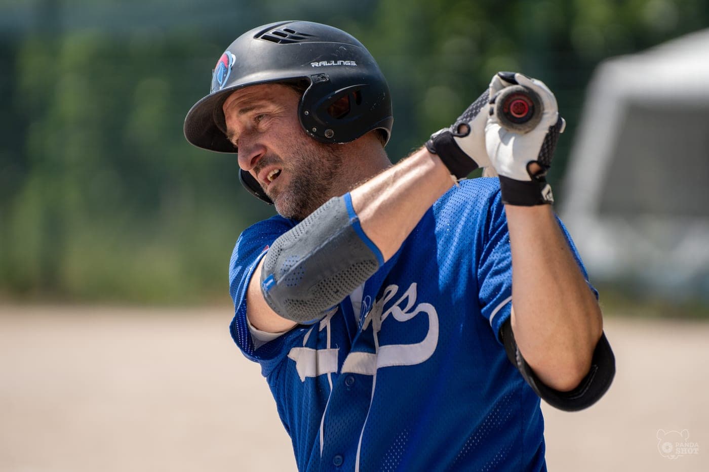 Un batteur de baseball, casque vissé, prêt à frapper.