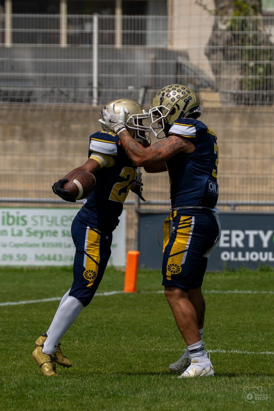 Deux joueurs de football américain se congratulent après une action.