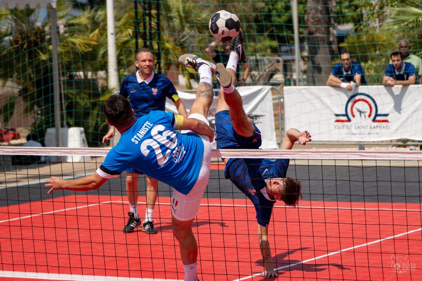 Un joueur reprend le ballon en retourné au-dessus du filet.