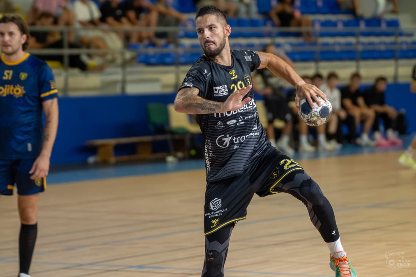 Un handballeur arme son tir en suspension.