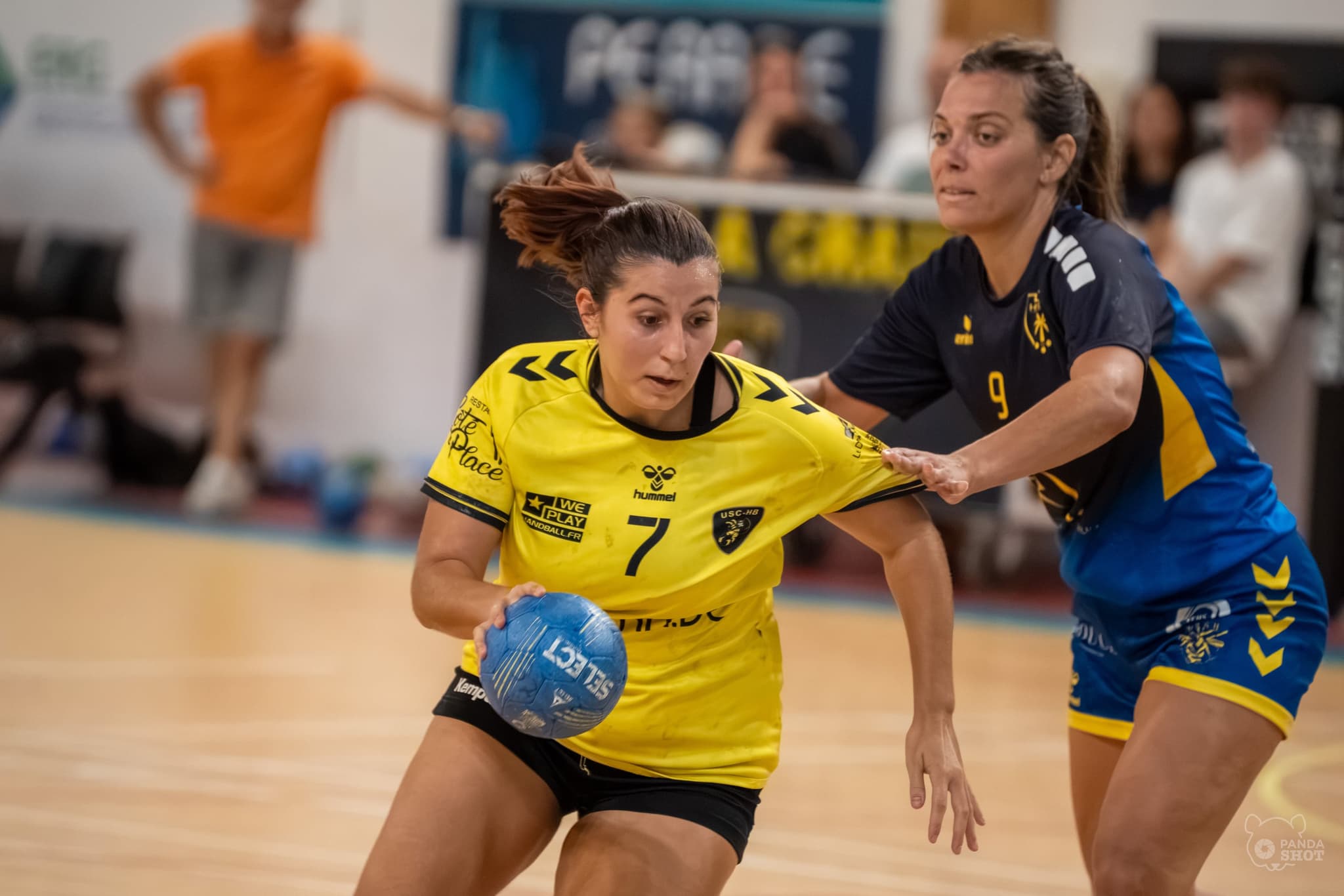 Une joueuse de l'US La Crau déborde son adversaire, maillot retenu par la défense